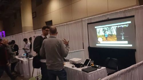 People at a demo booth with a projection screen at CHI 2014